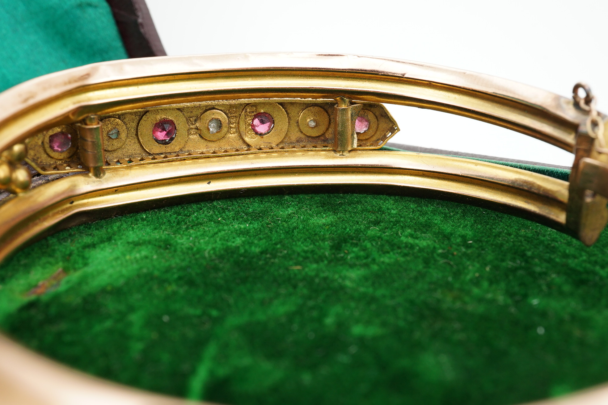 An Edwardian 9ct gold, and gypsy set ruby and diamond set hinged bangle, gross 11.4 grams, together with a gilt metal hinged bangle. Condition - poor.